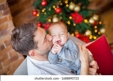 Dad Hugs Newborn Son Christmas Lights