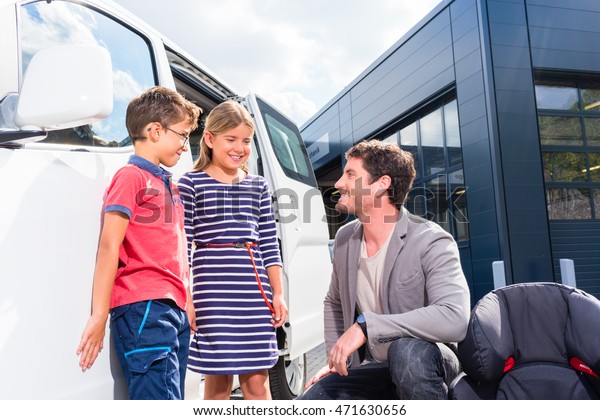 Dad\
with kids buying family car at dealer at yard, a van\
