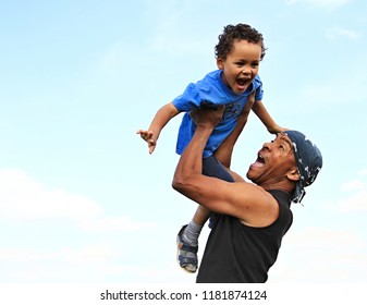 dad lifting his little boy