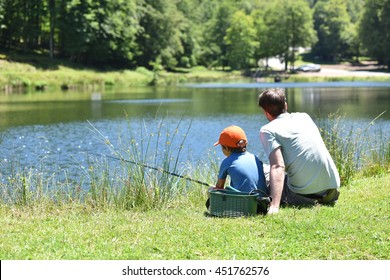 Dad With Little Boy Fishing By Mountain Lake