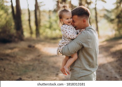 Dad With Little Daughter Hugging In Forest