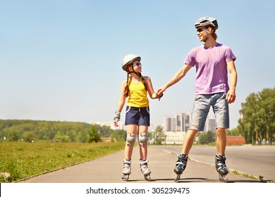 Dad with little daughter on the skates. two people rollerblade. sports family rollerskating outdoor