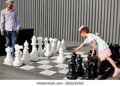dad and little daughter play giant chess in the park - Powered by Shutterstock