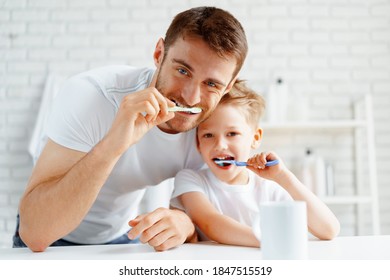 Dad And Little Son Brushing Teeth Together