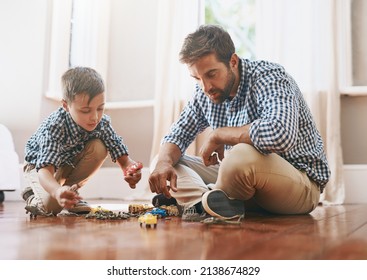 Dad Makes Time For Play In His Busy Day. Shot Of A Young Boy And His Father Playing With Cars On The Floor.