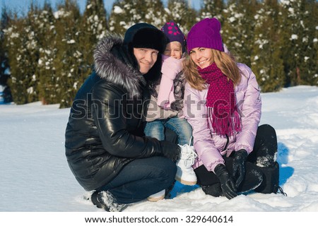 Dad mom and daughter on a background of winter trees and blue sky, lifestyle, winter vacation, fun