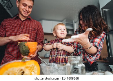 Dad, mom and little son in the kitchen, cook a pie
