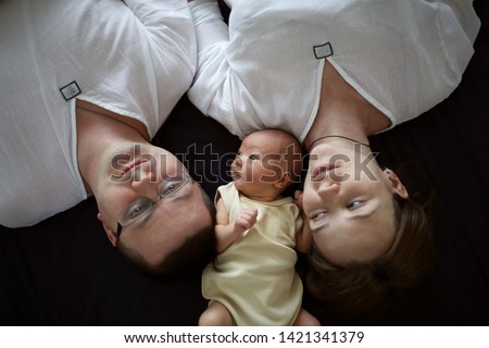 Similar – Mother reading book to her sons in the bed