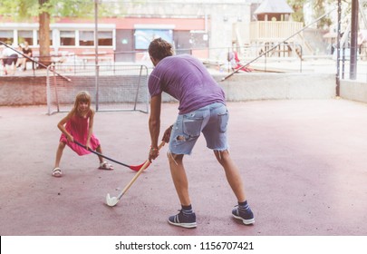 Dad Playing Floor Ball With Kid. Field Hockey Game At Children Playground. Active Free Time With Kids. 