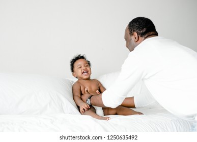 Dad Playing With His Baby On The Bed