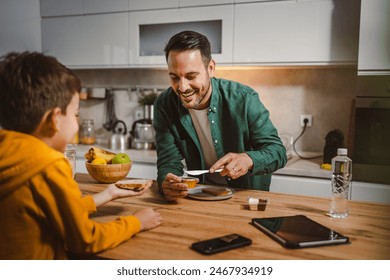 Dad prepare chocolate cream on bread while son pack backpack for school - Powered by Shutterstock