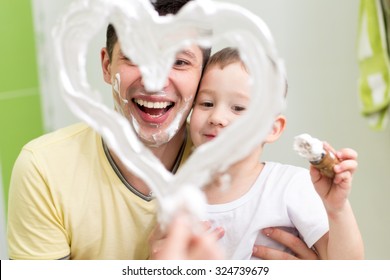 Dad And Preschooler Son Child Draw Heart Shape On Mirror With Shaving Foam Playing In Bathroom