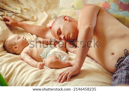 Similar – Mother reading book to her sons in the bed