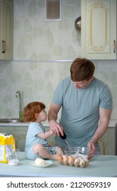 Dad With A Small Child Cooking In The Kitchen