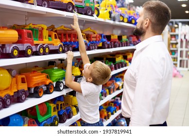 Papá con un niño pequeño en las filas de juguetes en una tienda para niños.