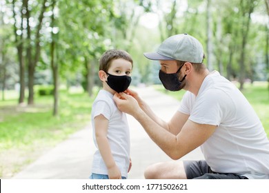 Dad and son in black face masks walking in the park. Social distansing and quarantine concept - Powered by Shutterstock