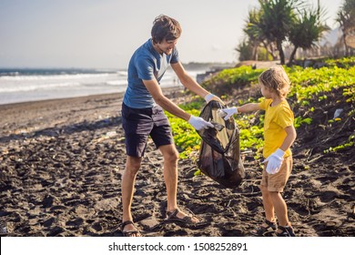 Dad and son are cleaning up the beach. Natural education of children - Powered by Shutterstock