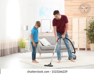 Dad And Son Cleaning Living Room Together