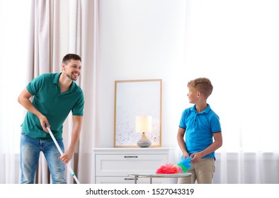 Dad And Son Cleaning Living Room Together