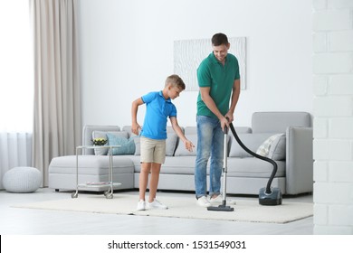 Dad And Son Cleaning Living Room Together