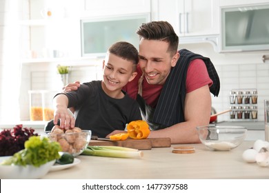 Dad And Son Cooking Together In Kitchen