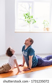 Dad Son Do Sport At Home. The Father Teaches Child A Healthy Lifestyle. Parenthood Modern Fatherhood. Love Harmony  Leisure Family Apartment Activity. Father's Day.  Yoga Asana Cobra Pose. Quarantine