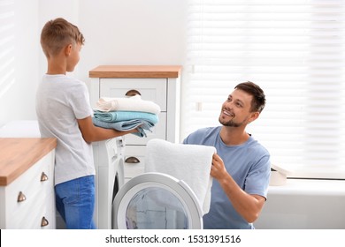 Dad And Son Doing Laundry At Home