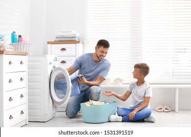 Dad And Son Doing Laundry At Home