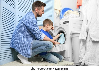 Dad And Son Doing Laundry At Home