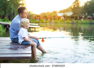 Dad And Son Fishing On Lake