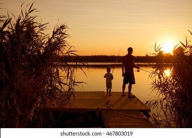 Dad And Son Fishing On The Lake