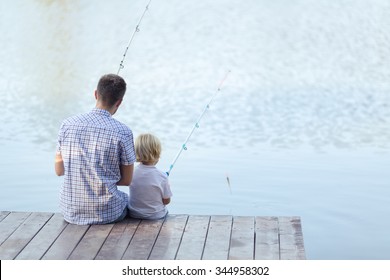 Dad And Son Fishing On A Pier