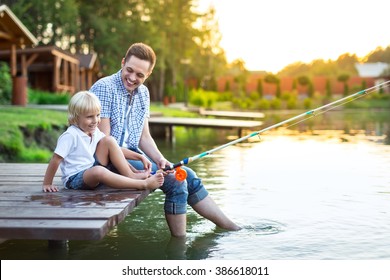 Dad And Son Fishing In Summer