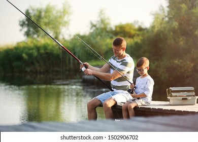 Dad and son fishing together on sunny day - Powered by Shutterstock