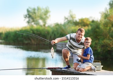 Dad And Son Fishing Together On Sunny Day