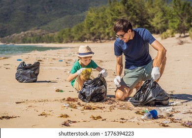 Dad and son in gloves cleaning up the beach pick up plastic bags that pollute sea. Natural education of children. Problem of spilled rubbish trash garbage on the beach sand caused by man-made