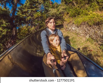 Dad And Son Have Fun On Alpine Roller Coaster