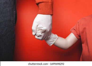 Dad and son are holding hands in disposable medical gloves. Quarantine Concept
