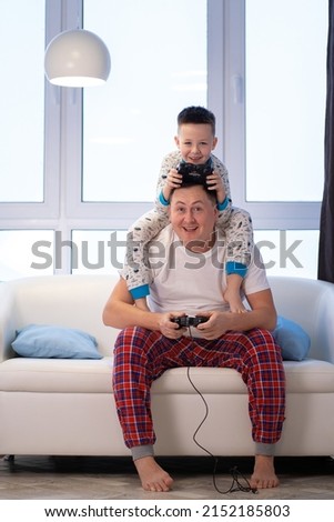 Dad and son play video games at home and fool around
