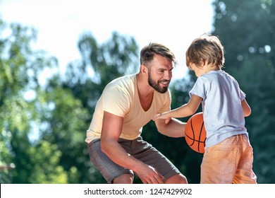 Dad And Son Playing Basketball On The Court