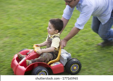 Dad And Son Playing With Toy Outdoors