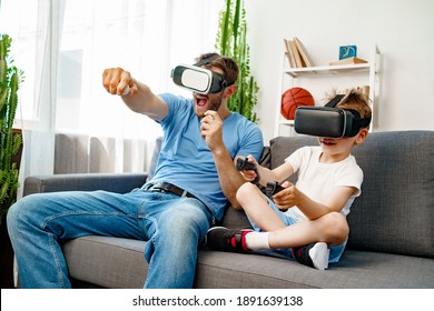 Dad and son sitting on sofa and playing games with VR glasses - Powered by Shutterstock