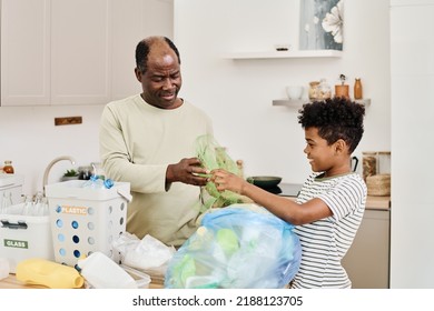 Dad and son throwing garbage in packet together - Powered by Shutterstock