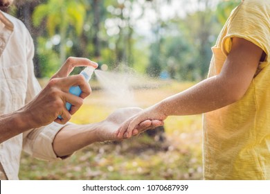 dad and son use mosquito spray.Spraying insect repellent on skin outdoor