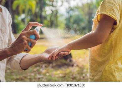 dad and son use mosquito spray.Spraying insect repellent on skin outdoor - Shutterstock ID 1081091330