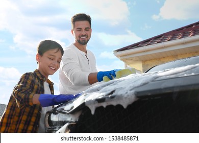 Dad and son washing car at backyard on sunny day - Powered by Shutterstock