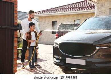 Dad and son washing car at backyard on sunny day - Powered by Shutterstock