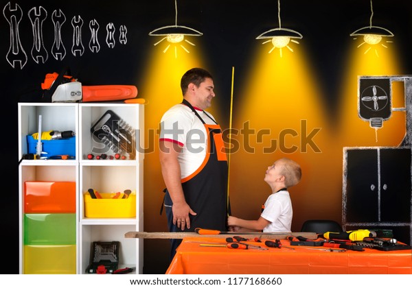 Dad and son work\
together in workshop.