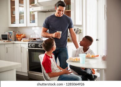 Dad Standing In The Kitchen Talking With His Son And A Friend, Who Is Over For A Playdate