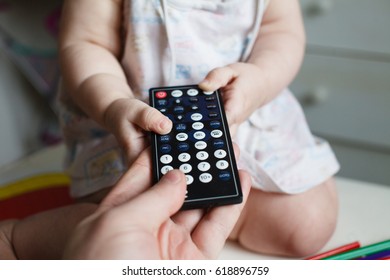 Dad takes the remote from the TV in the child.